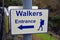 Walkers entrance sign with arrow and hiker with rucksack symbol
