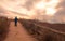 Walking alone on sandy path at sunrise