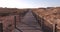 Walking along wooden boardwalk over sand dunes