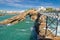 Walking on beautiful footbridge leading to rocher de la vierge on atlantic coastline with cliffs and turquoise ocean in biarritz,