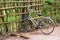 Walking bicycle with a basket near a bamboo fence