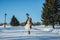 Walking bride on a snowy road. beautiful brunette in a short wedding dress, rustic style, with the pine-tree wedding bouquet, and