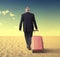 Walking businessman with suitcase in a desert