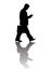 Walking businessman with suitcase looking at smartphone, full length silhouette with reflection