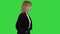 Walking businesswoman with hands in pockets on a Green Screen, Chroma Key.