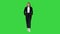 Walking businesswoman with hands in pockets on a Green Screen, Chroma Key.