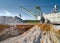 Walking excavator takes chalk with bucket in open quarry