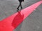 Walking lonely man on red carpet close view on legs