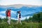 Walking in the mountains. Guy and girl with backpacks are on path on hilltop