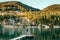 Walking in nature concept image. Male dog owner and his friend beagle dog on the wooden pier on the mountain lake during their