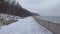 Walking path by the Baltic Sea in Gdynia, Poland during winter. December 2023. Snowy beach.