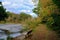 Walking Path and Bench With Peaceful Lake View in Autumn