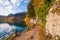 Walking path with a fence along alpine lake Wolfgangsee in austrian Alps