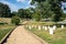 A walking path leads through Arlington National Cemetary in Arlington Virginia, with rows of white stone, military grave markers