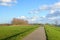 Walking path over an embankment along a wide Dutch river