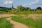 Walking path through polders of river Scheldt with little church, Flanders, Belgium