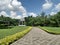 Walking path to white gazebo under white cloud and blue sky