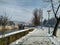 Walking pedestrian lane covered in snow during winter holiday season during sunny cold day next to a river and bridge