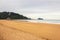 Walking people on wide beach of Biscayne bay, Spain. Surf beach with surfers and mountain on background. Active lifestyle concept.