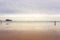 Walking people on wide beach of Biscayne bay, Spain. Surf beach with surfers and mountain on background. Active lifestyle concept.