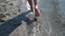 Walking in Shoal. Top view of barefoot man vacationer walking along the beach and sea waves washing his feet.