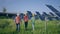 Walking to the camera happy group of investors and ecological engineer at photovoltaic solar farm they analysing the