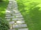 A walking track made of stone slabs among grass