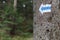 Walking trail marks and signs on trees showing direction for hikers in forest