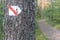 Walking trail marks and signs on trees showing direction for hikers in forest