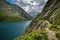 Walking trail next to stone wall above Gelmersee lake in Swiss Alps