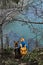 Walking and traveling with dog. Dog with owner on the sea. Girl with yellow backpack and hat sits on the edge of cliff overlooking