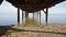 Walking underneath a pier at the Tagus river in Lisbon