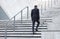 Walking up to success. Shot of an unrecognizable businessman walking up stairs in the city.