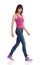 Walking Woman In Magenta Tank Top, Jeans And Sneakers. Side View.