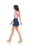 Walking Young Woman In Jeans Mini Skirt And Wedge Shoes. Side View