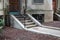 Walkway and concrete steps entryway to a brownstone apartment building with wrought iron railings