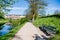 walkway, empty benches and green trees near calm pond