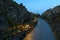 Walkway goes through a beautiful volcanic terrain with black volcanic rocks and turquoise water at blue lagoon geothermal spa in