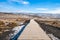 Walkway of gullfoss waterfall in Iceland surrounding by grass field with blue sky