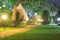 The walkway and lawn of the resort at night, with orange light o