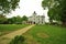 Walkway leading to classic vintage brick and stone house framed by trees in yard