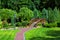 Walkway leading to a decorative wooden bridge over a pond.