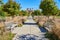 Walkway lined with benches and fall grasses leading to old ruins