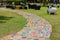 The walkway is made of cement and Colorful Brick on the grass in the garden