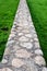 Walkway made of rocks and concrete over a green lawn