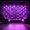 Wall adorned with bright purple LED lamps, creating an incandescent atmosphere