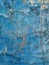 A wall adorned with worn blue paint showcases a mosaic of cracks, a testament to the relentless passage of time.