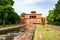 The wall around Taj Mahal complex in Agra, Uttar Pradesh, India with green gardens and water pool