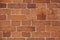 The wall of the building is made of old red brick. Background for text, posters. The brick is destroyed, the brick crumbles. Lots