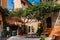 wall of a building with potted plants. Charming facade with shutters. Paved sidewalk